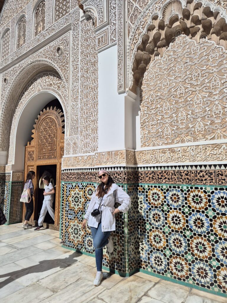 Mujer explorando la arquitectura árabe de la Medersa Ben Youssef en Marrakech
