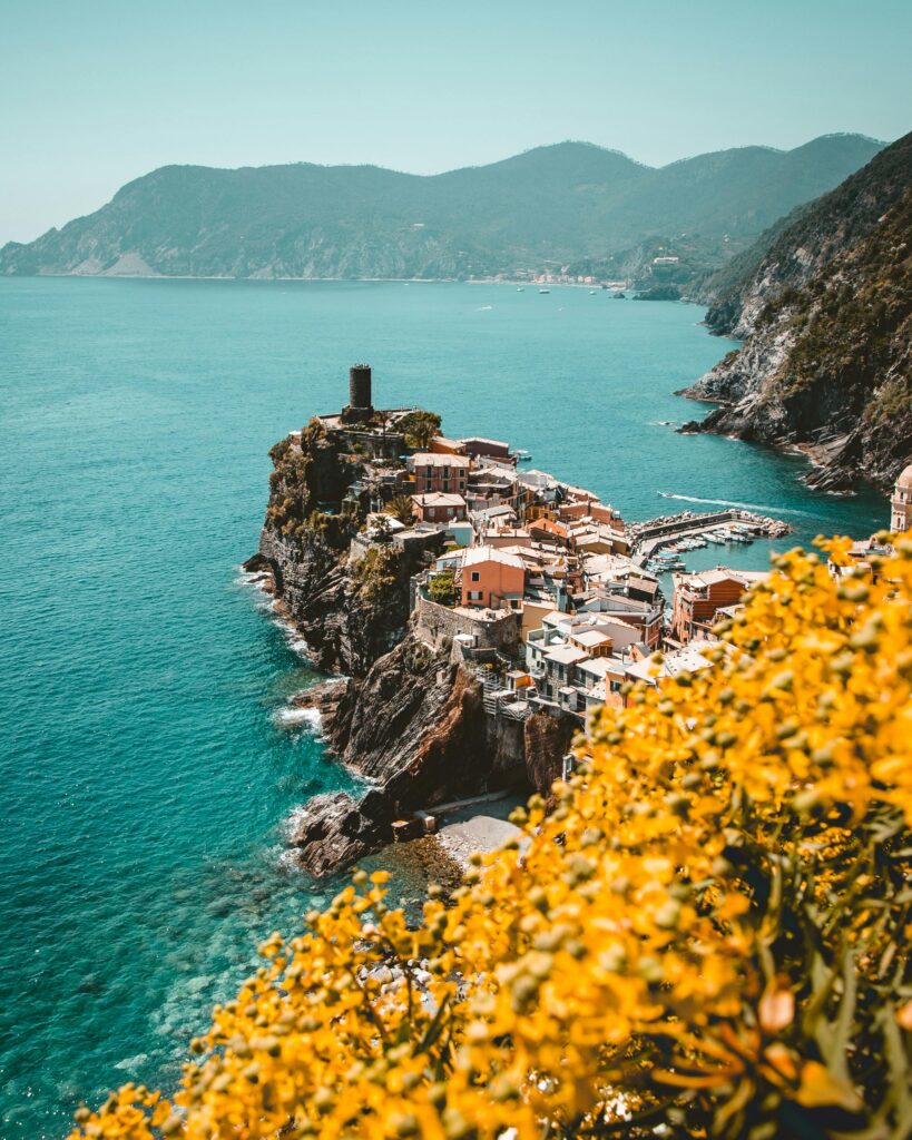 Vista de los acantilados de Cinque Terre con el mar azul de Liguria al fondo, representando la belleza natural y el paisaje costero del norte de Italia.