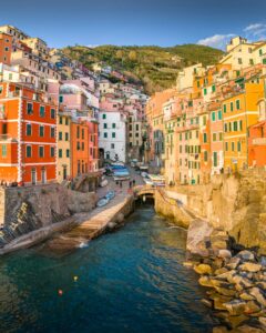 Casitas de colores apiladas sobre la colina frente al mar en Cinque Terre, símbolo del encanto y la belleza del norte de Italia.