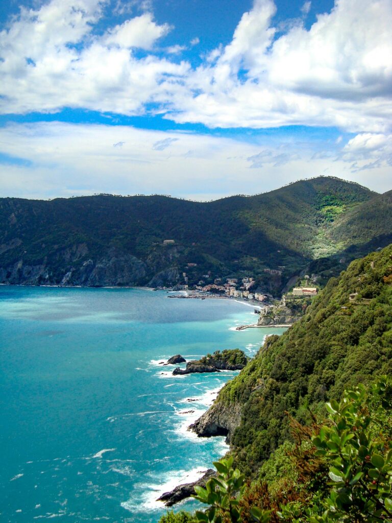Vista panorámica de las montañas verdes que rodean Cinque Terre, con el mar Mediterráneo al fondo, representando la belleza natural de la región de Liguria en el norte de Italia
